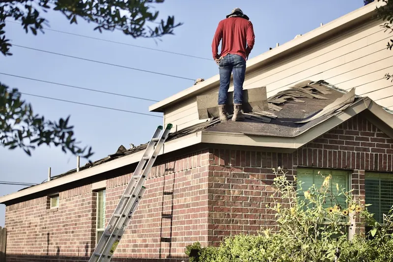 Professional roofer working on a residential roof in Higbeeville